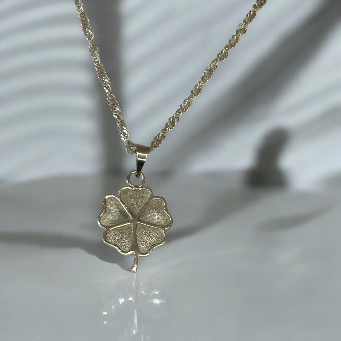 Dije trébol con cadena.